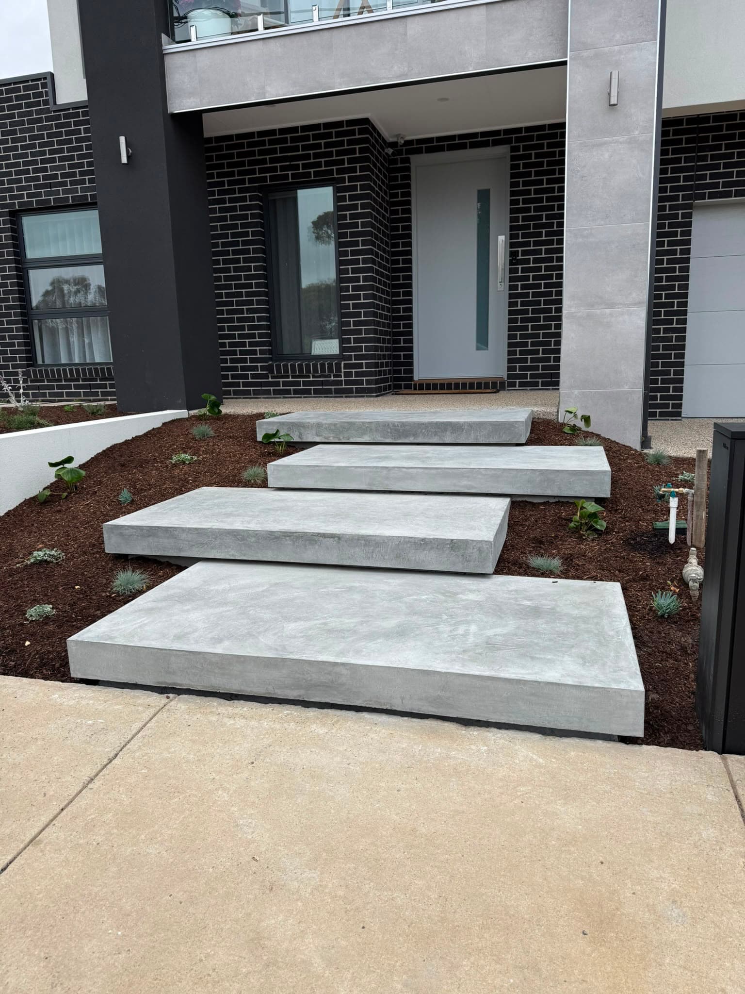 Modern entry with concrete steps and white retaining walls