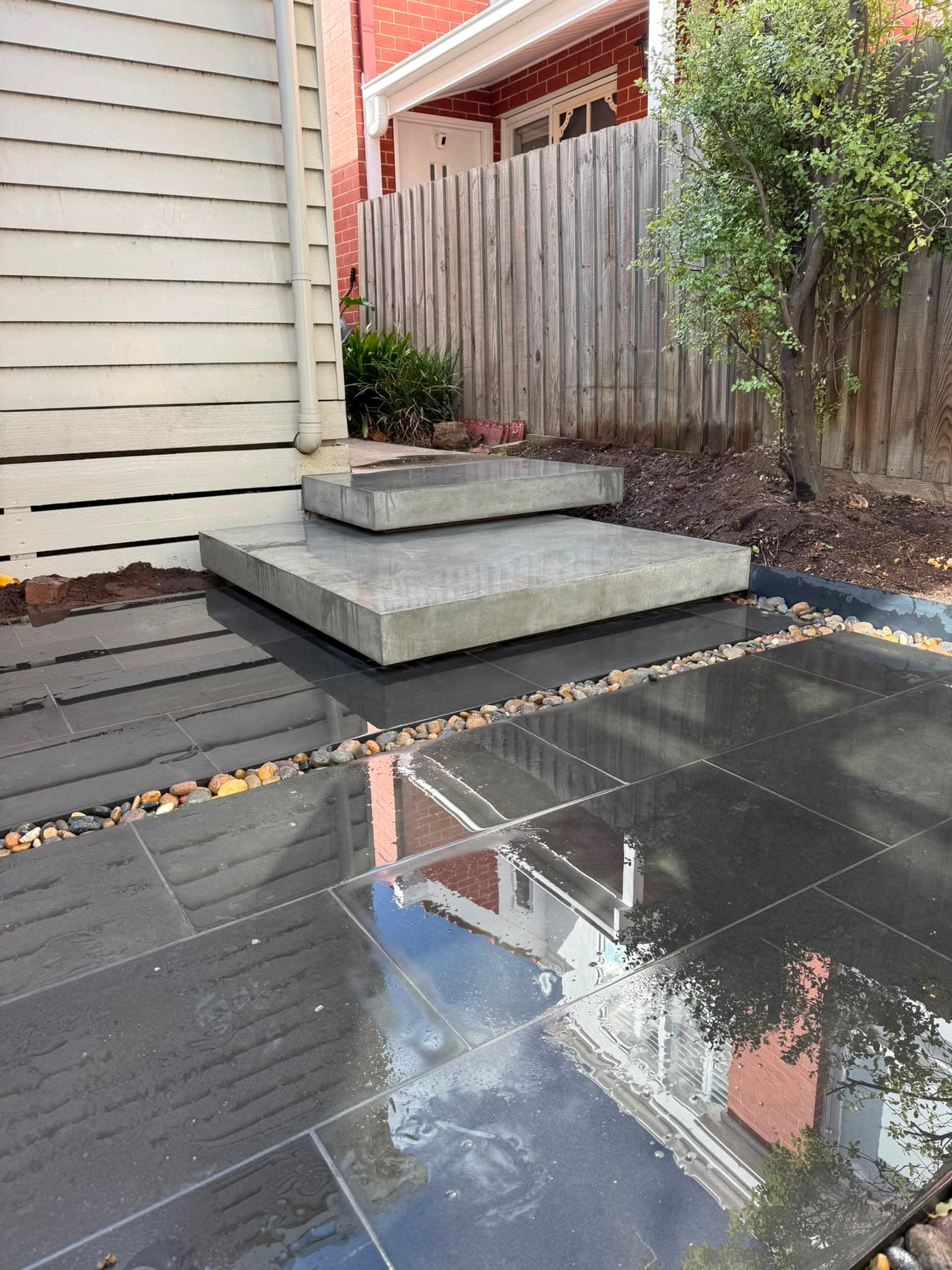 Modern courtyard with tiered concrete steps and minimalist plantings