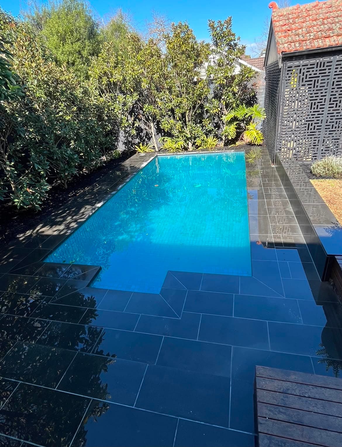 Wooden deck construction adjacent to modern glass house